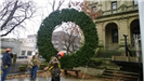 Hanging a large holiday wreath on a public building with a crane