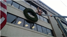 A large holiday wreath on the side of a public building 2