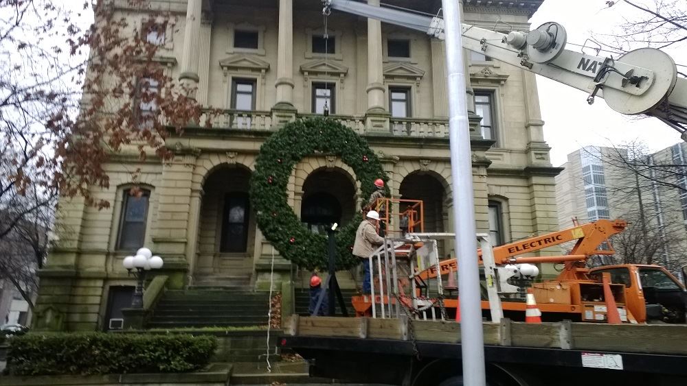 Hanging a large holiday wreath on a public building with a crane 4