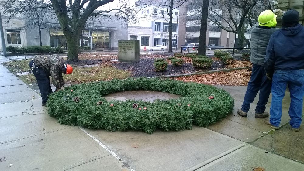 A large holiday wreath laid out on the ground