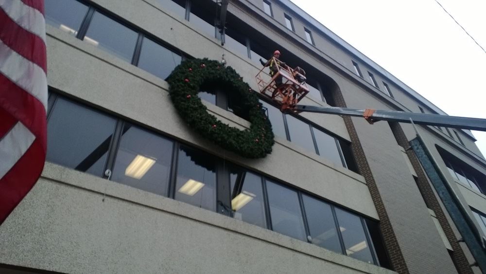 A large holiday wreath on the side of a public building 2