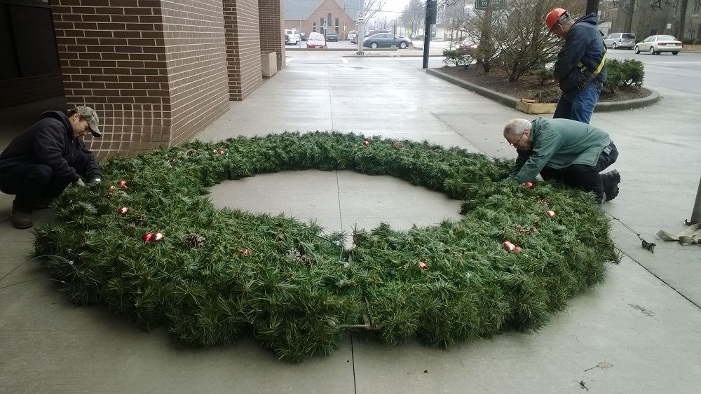 A large holiday wreath lying on the ground
